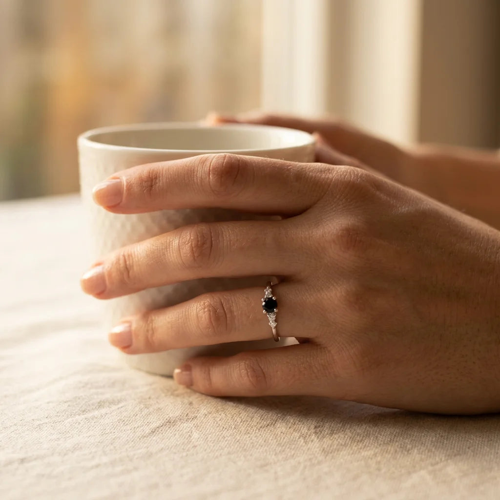 Obsidian Ring am Finger neben Kaffeetasse