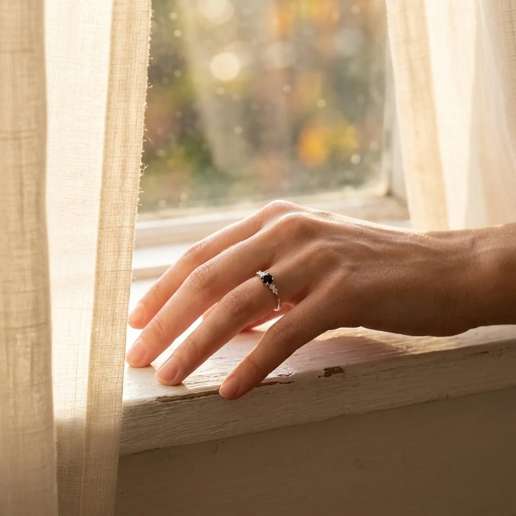 Obsidian Ring an der Hand am sonnigen Fenster